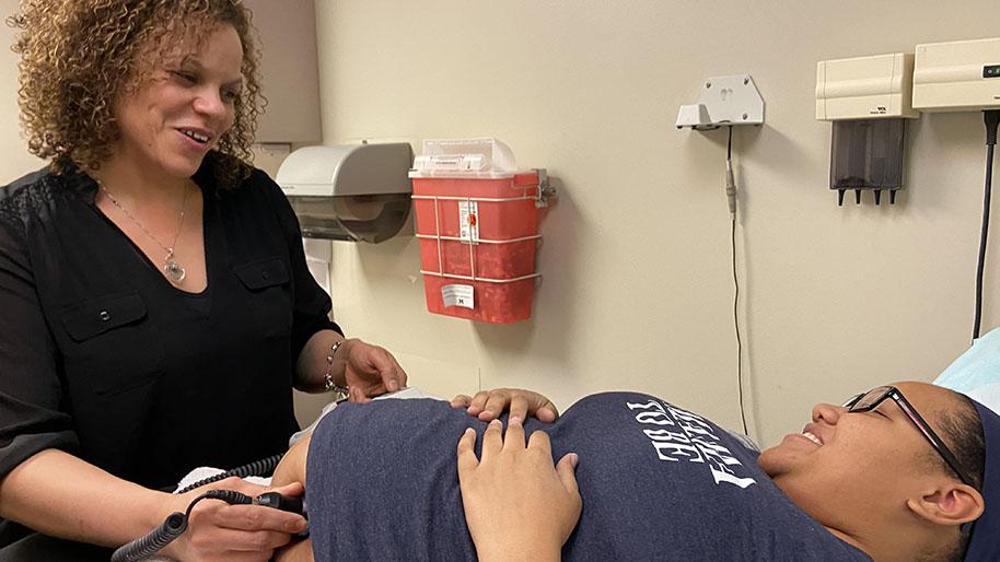 A nurse midwife performing an ultrasound on a pregnant woman