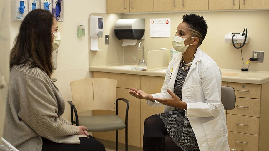 Dr. Versha Pleasant talking with a patient in a clinic room