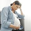 Pregnant woman with her head resting against her hand